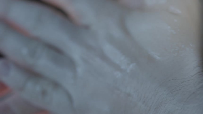 A person with a squirt bottle squirting liquid on their hands