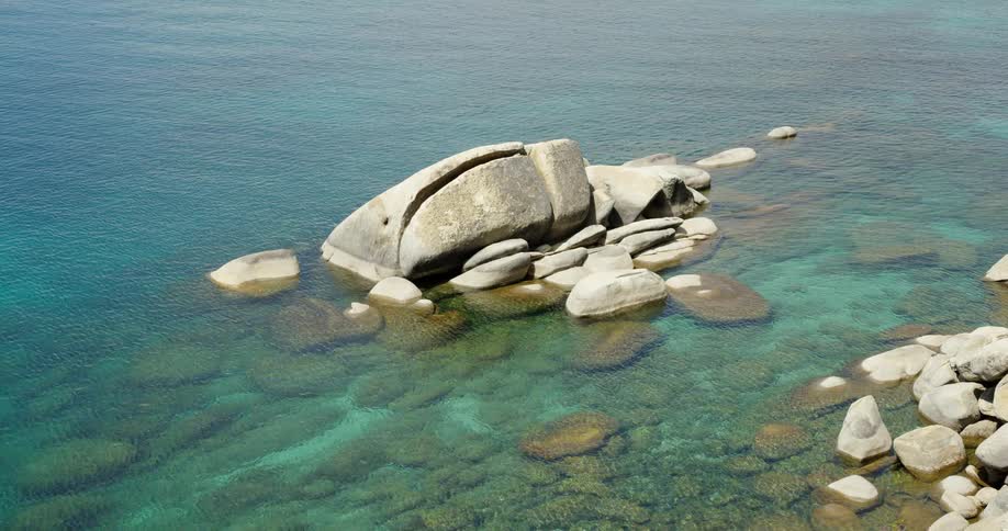 Rocks half submerged on the green coastal waters at day