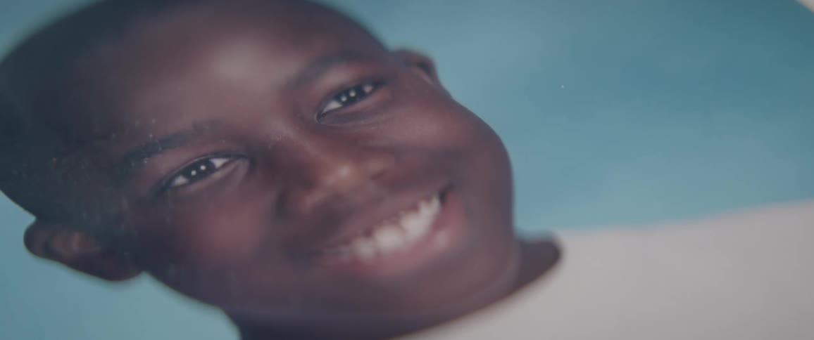 The face of a smiling boy in a school picture