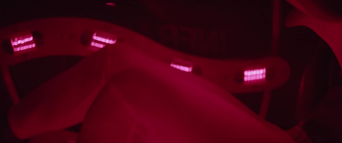 Legs pedal a stationary bike while lights flash red