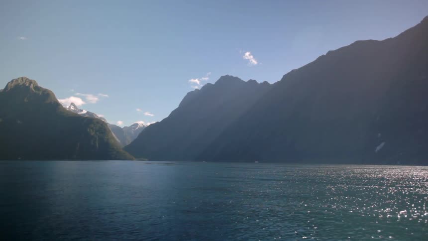 A large lake leads to a mountain range on a sunny day