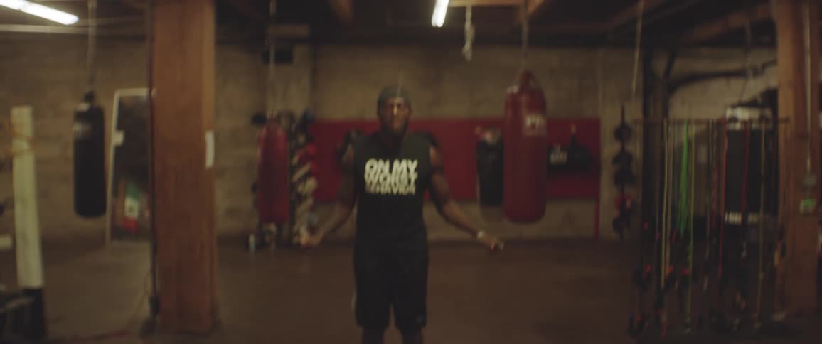 A male athlete is jumping rope in a gym