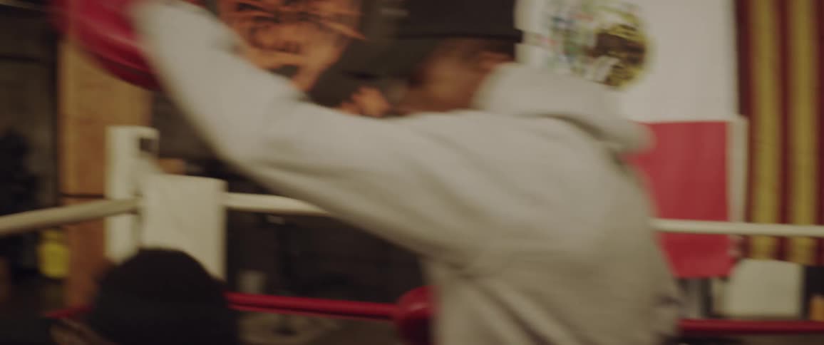 A boxer is training in a boxing ring in a gym