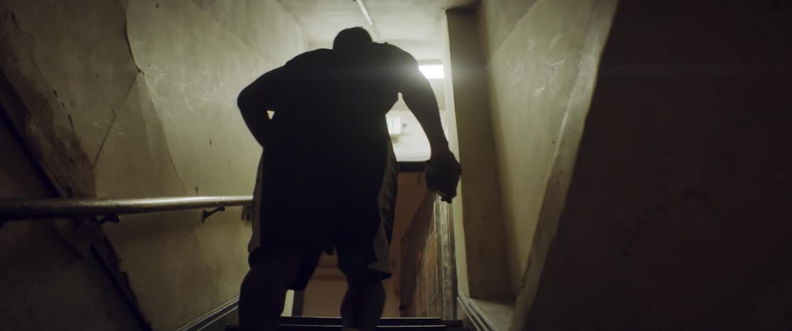 A man carrying boxing gloves walks up a set of stairs