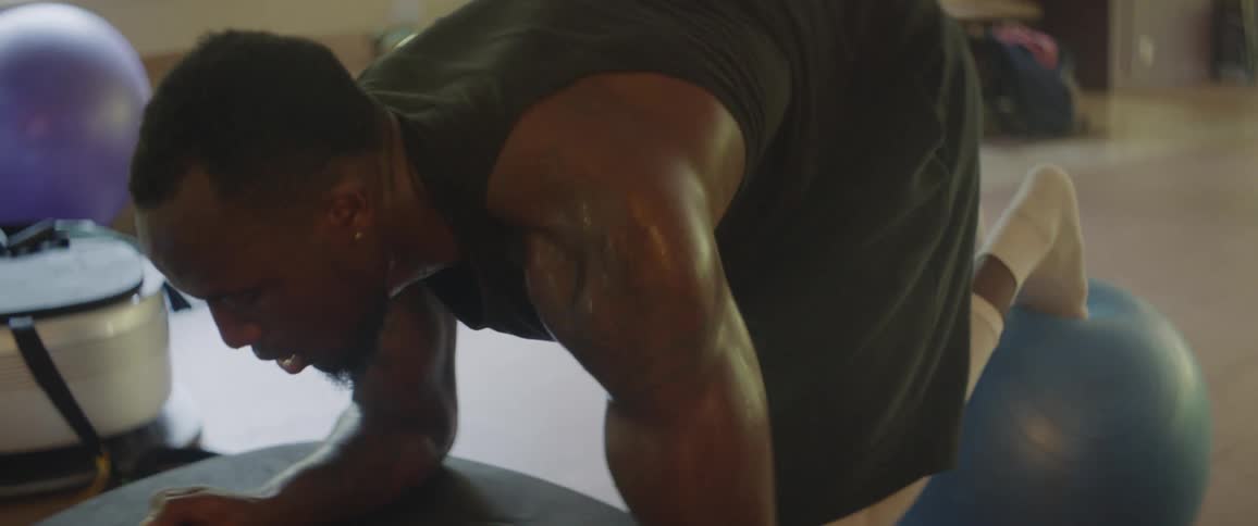 A man exercising with his legs on a ball