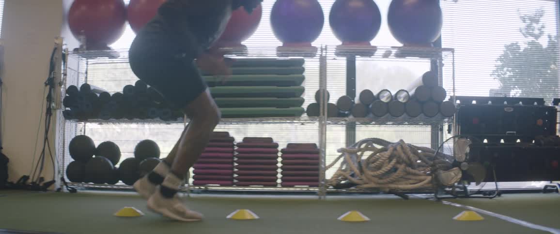 A man is doing laps backwards in the gym