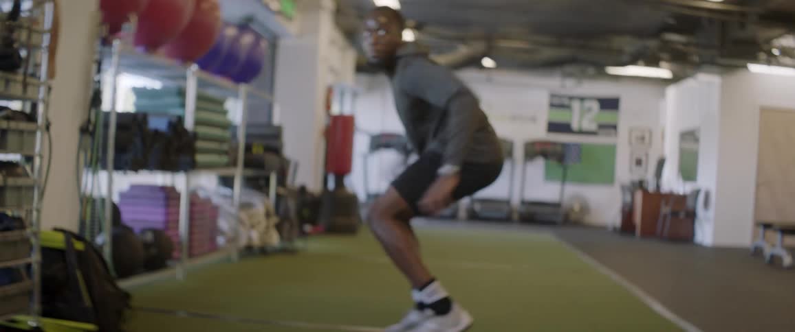 A man runs in a gym to catch the football