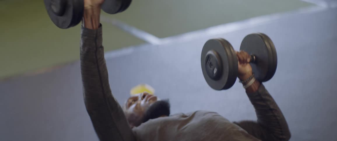 A person lifting and grabbing dumbbells in a gym