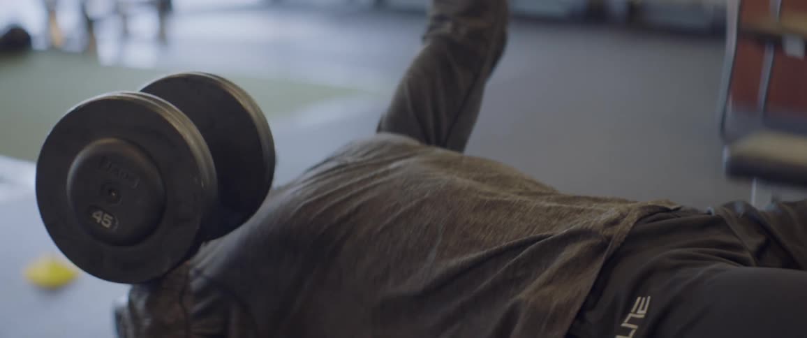 A man lifts weights in a gym