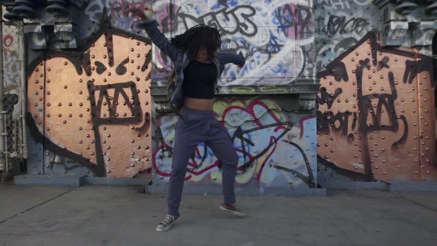 A woman is dancing on the sidewalk