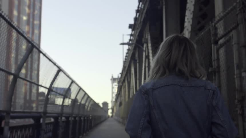 A woman is walking across a platform looking around