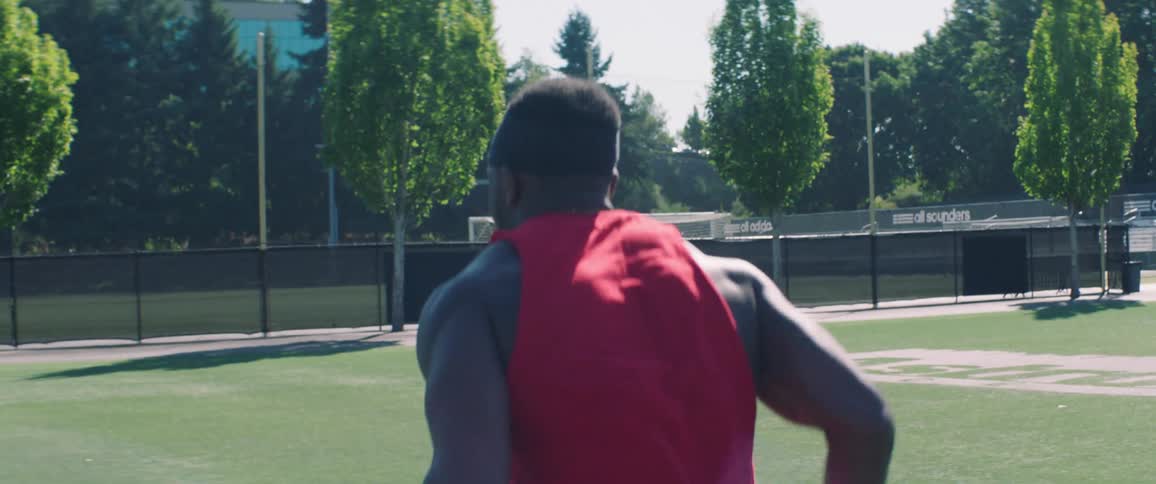 A player jumps over obstacles then catches a football