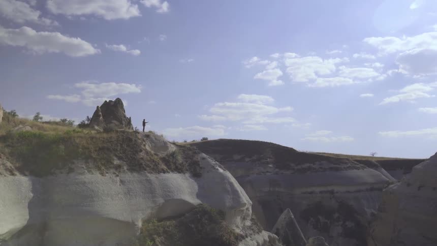 A single person is standing at the top of a mountain