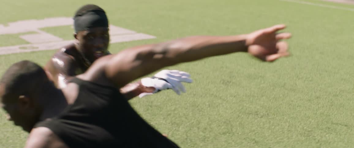 Two men play football on a sunny day