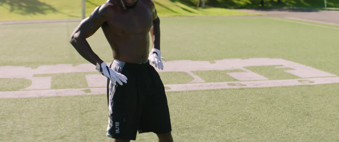 A man catches his breath after exercising on a sports field