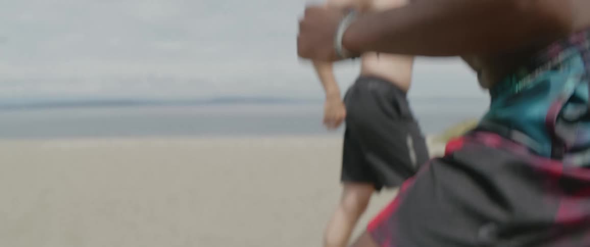 Shirtless man hops up and down on a cloudy day