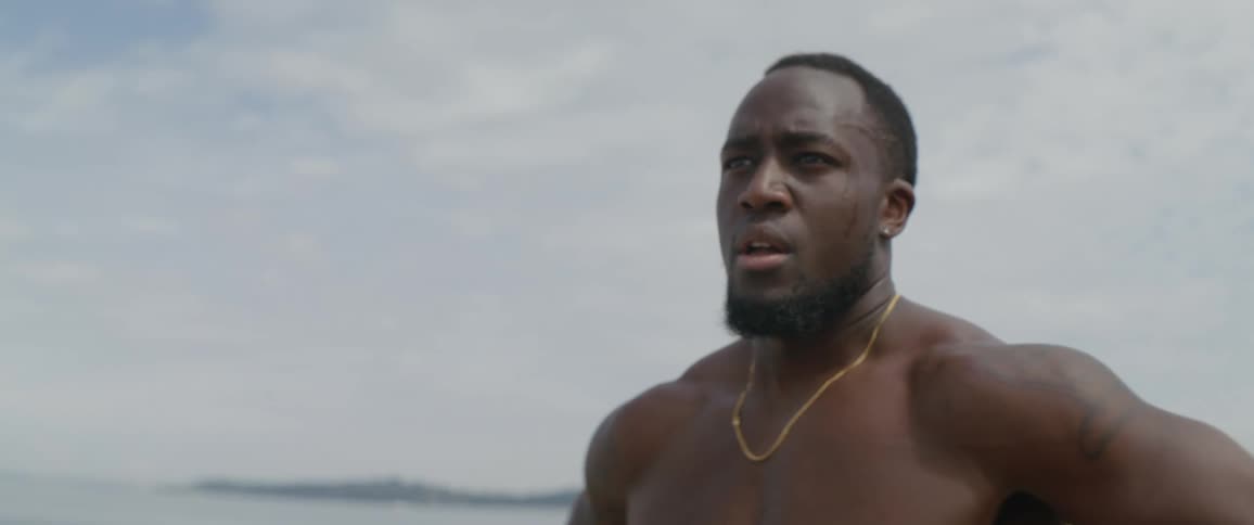 Man stands breathing outside with hands on his hips