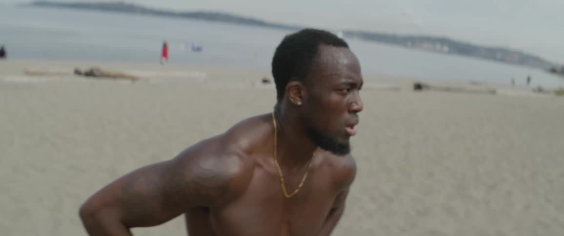 A man on a beach takes some deep breaths and rests