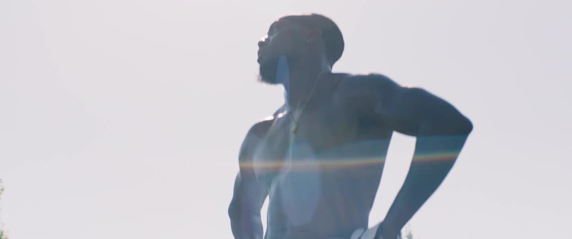 A man stands under the bright sun outdoors