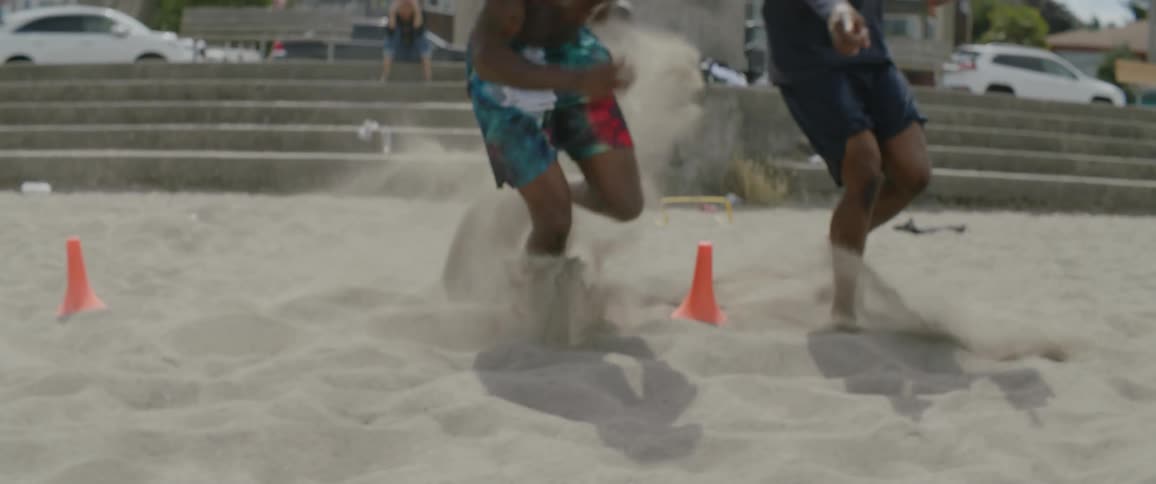 A few people running around on the sand and playing games