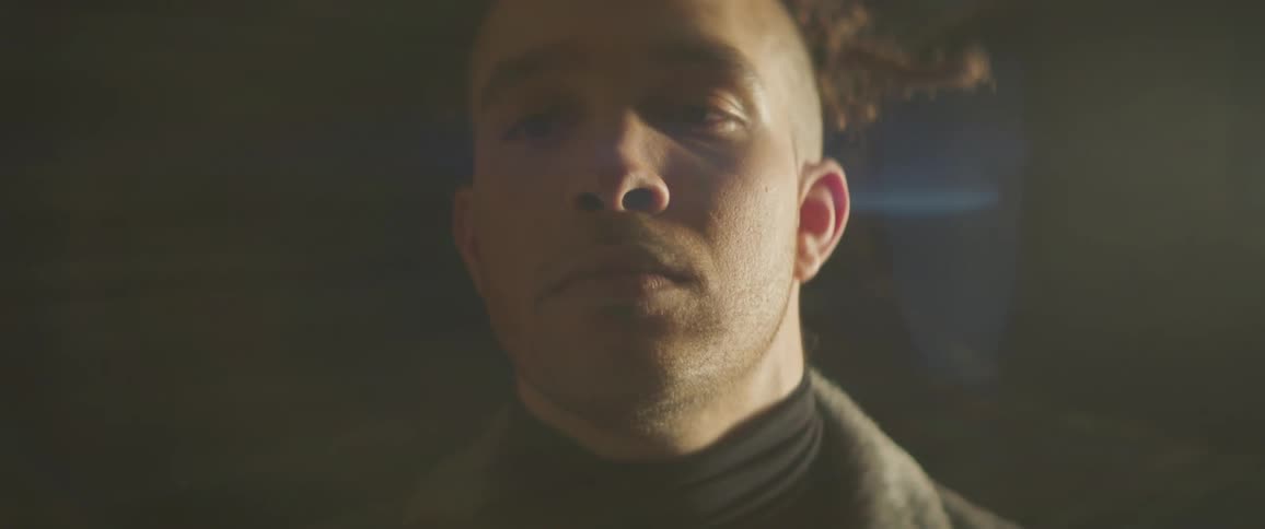 A man is adjusting the collar on his jacket