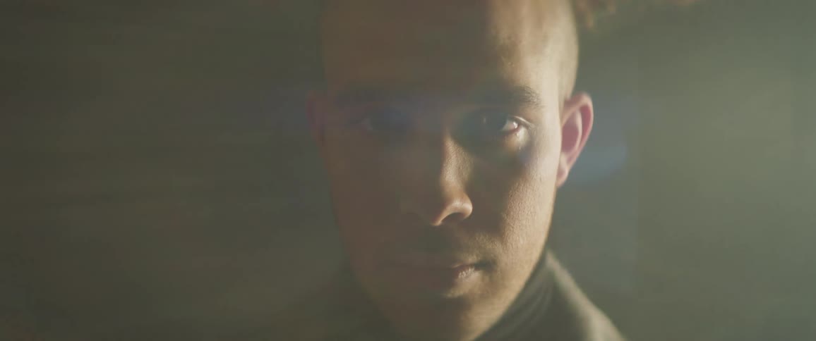 Man looking solemnly into the camera in a hazy area