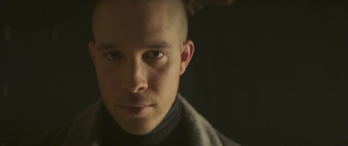 A man in a jacket stares ahead