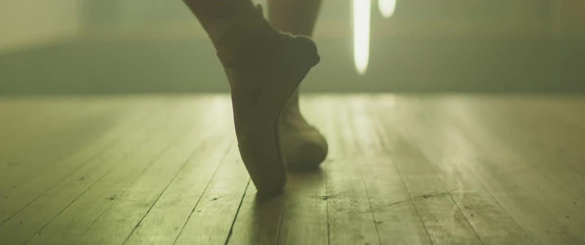 Ballerina spinning on toes in room while lights flash on and off