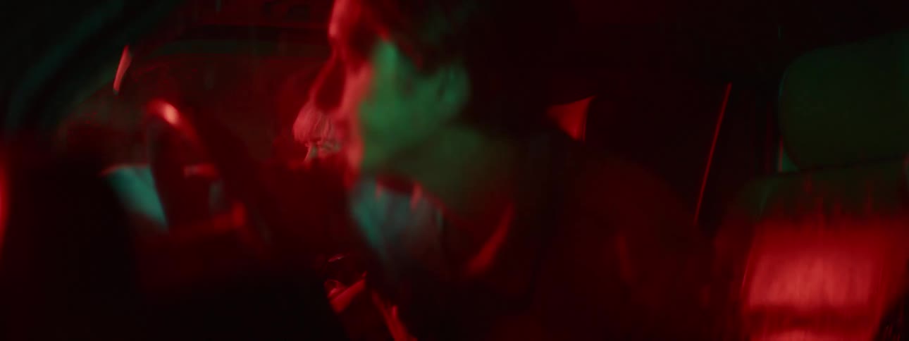 Woman refuses her boyfriend kiss inside a car under red and blue lights