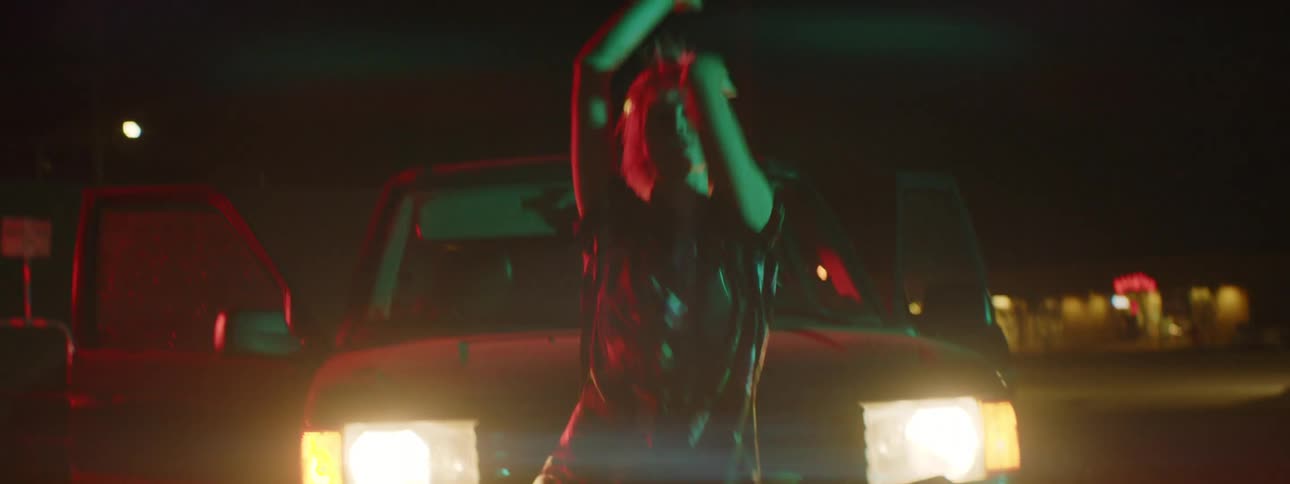 A person dancing at night near a truck
