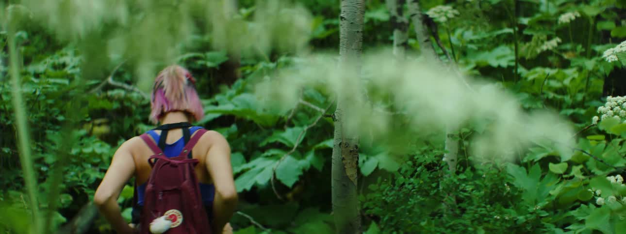 A teenage girl hiking through a forest