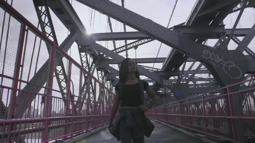 A woman is walking across a platform on a cloudy day