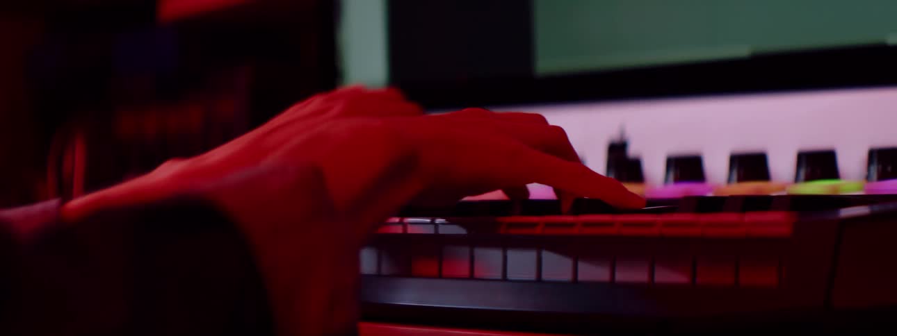 A musician plays the keyboard in a professional mixing studio