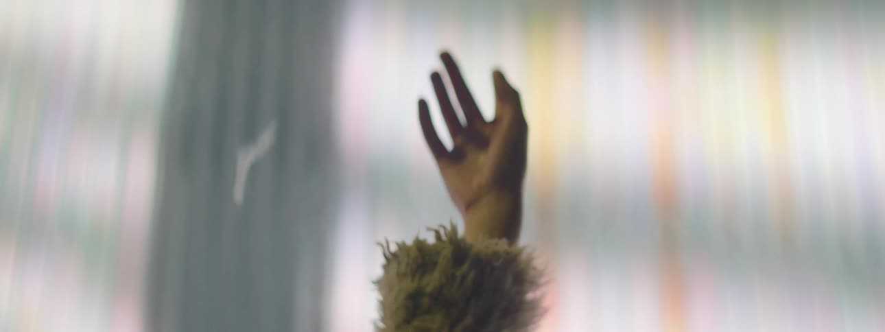 A teenage girl dancing in front of bright lights