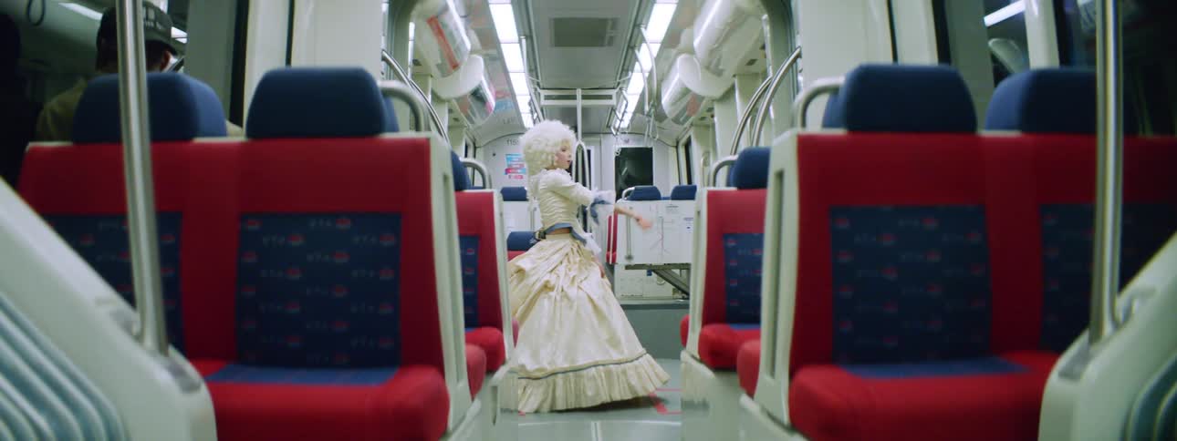 A teenage girl in costume dances and performs on a bus
