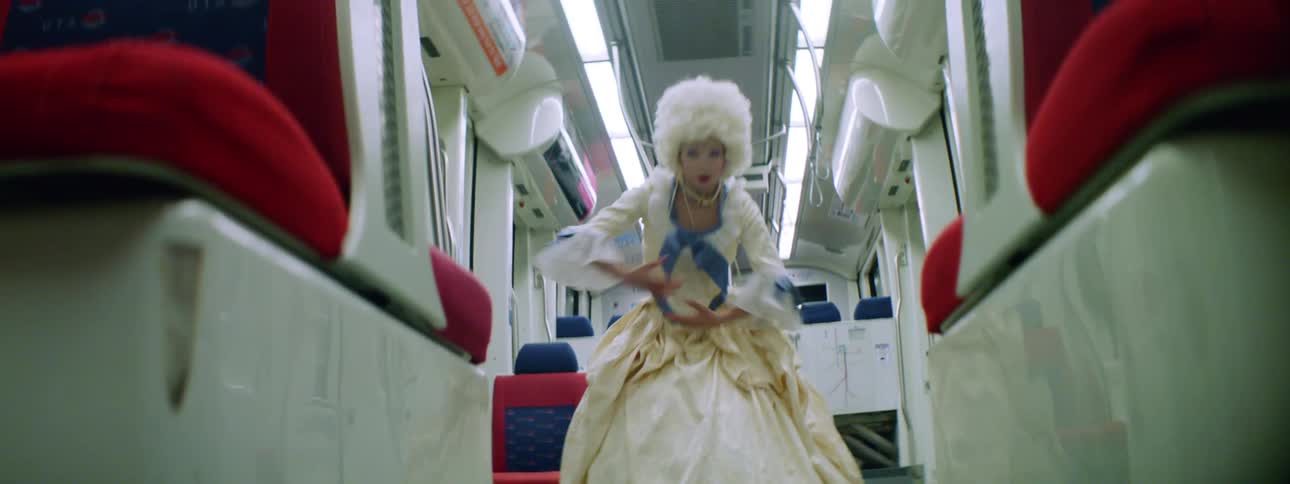 A teenage girl in costume performs on a bus