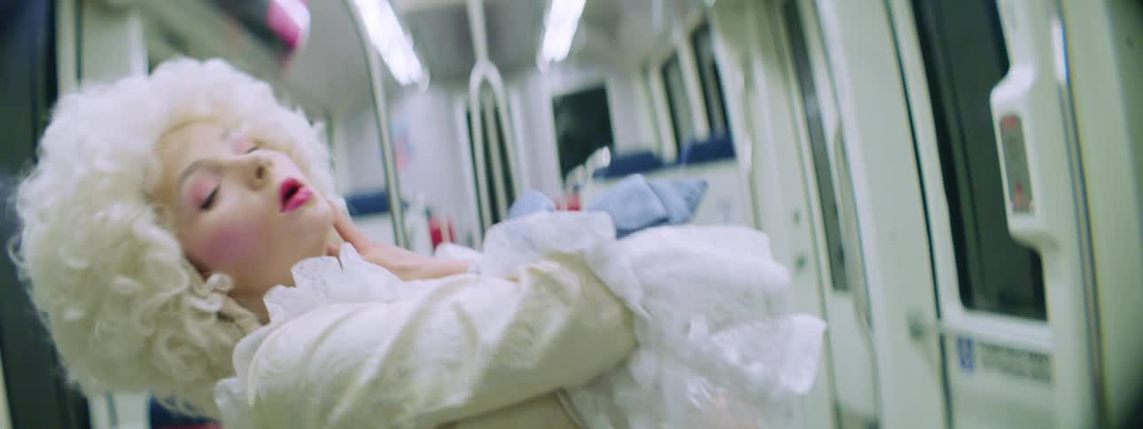 A teenage girl in costume dances and performs on a bus