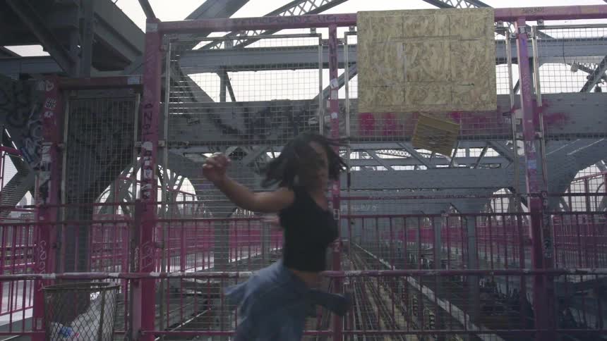 A woman is dancing near the train tracks
