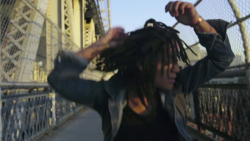 A woman dances down a sidewalk