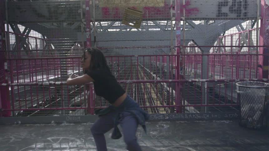 A woman is dancing on platform above the tracks