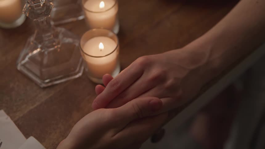 Two people are holding hands indoors