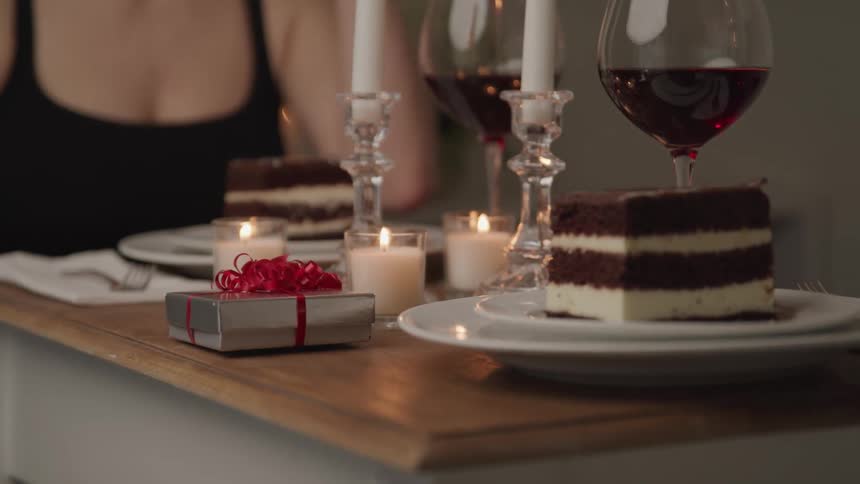 Romantic dinner with cake and wine and a small present on the table
