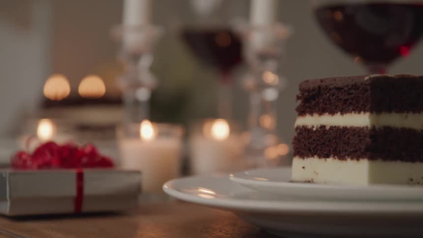 Chocolate and vanilla cake sits on a plate as a wrapped gift sits next to it