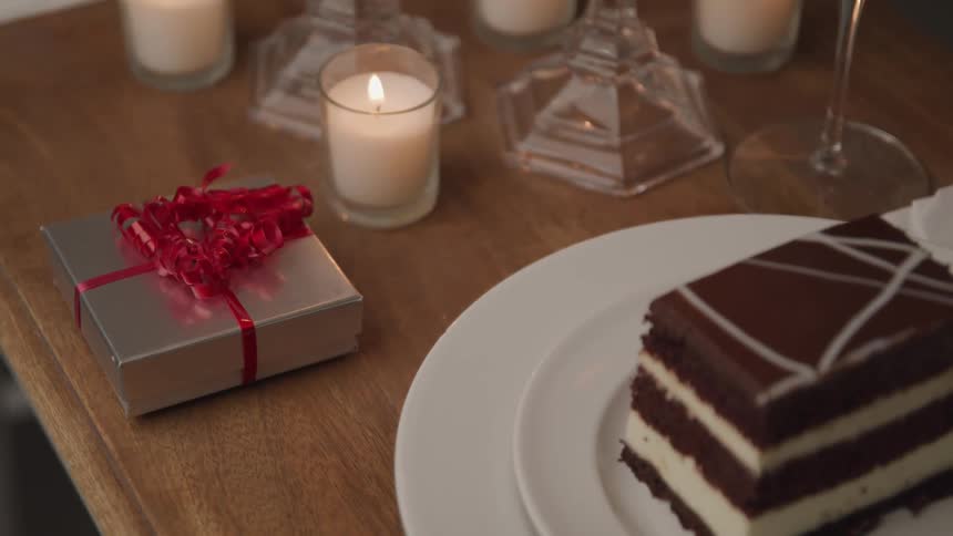 The table is set with a piece of cake candles and a gift