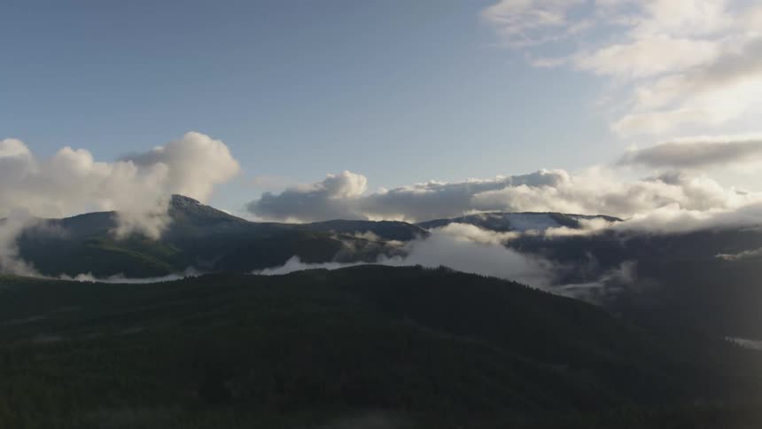 Clouds moving across tree covered hills