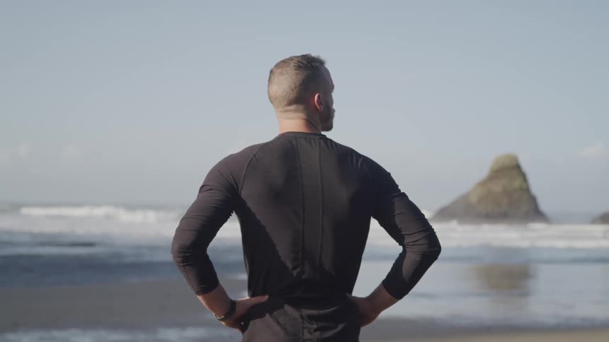 A man is standing on the beach
