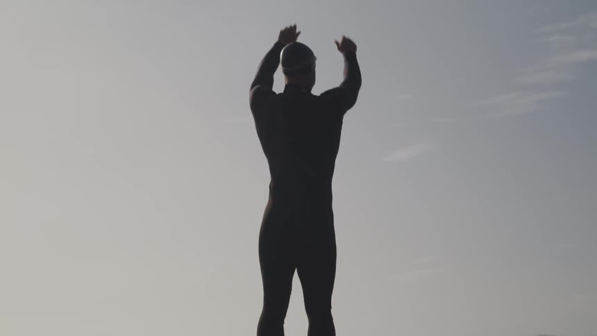 A man is standing by the beach