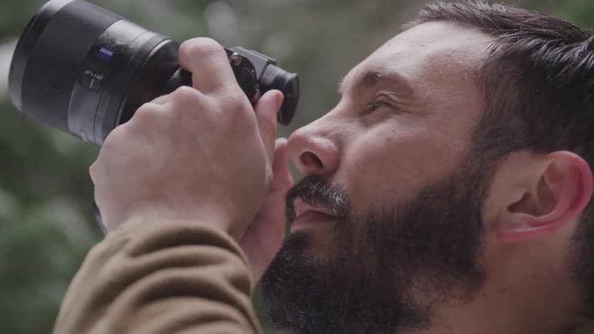 Man raising dslr camera to face to take photo