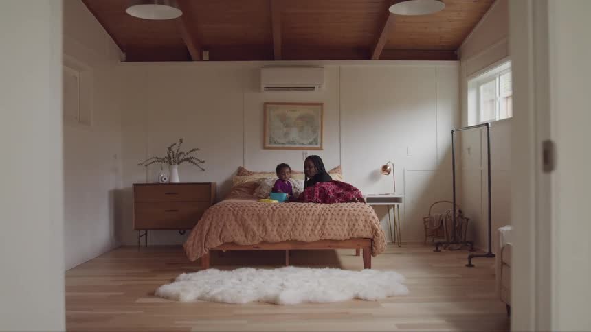 Mother and son relax leisurely on a bed in the bedroom at home