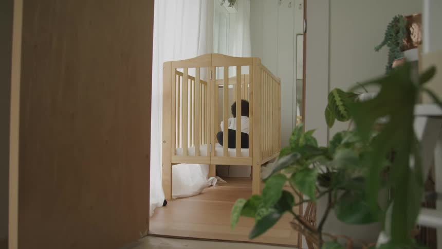 A baby sitting in a crib